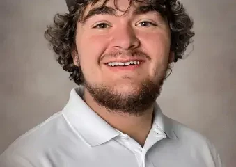 Young man in cap smiling in studio portrait