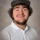 Young man in cap smiling in studio portrait