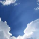 Blue sky with white clouds and sun rays