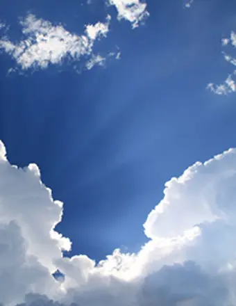 Blue sky with white clouds and sun rays