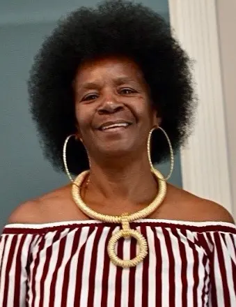 Smiling woman with afro and bold gold necklace