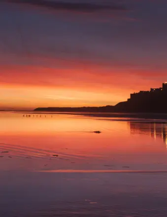 Sunset over calm beach with colorful sky reflections