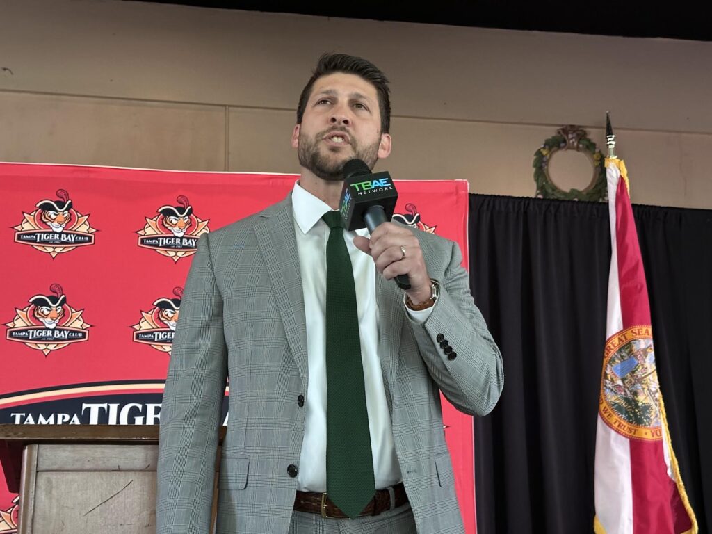 Man speaking at podium with Florida flag