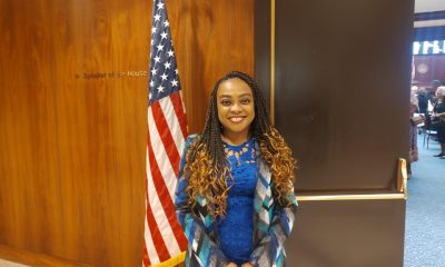 Woman standing by U.S. flag indoors