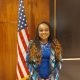 Woman standing by U.S. flag indoors