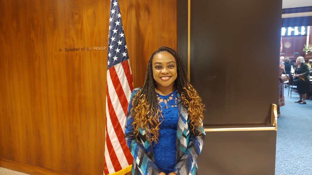 Woman standing by U.S. flag indoors
