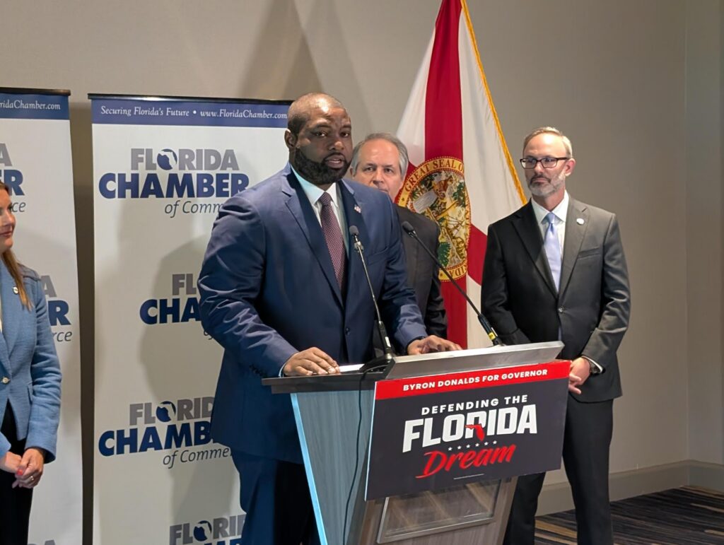 Man speaking at Florida campaign event podium