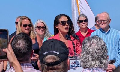 Woman speaking at outdoor political rally podium