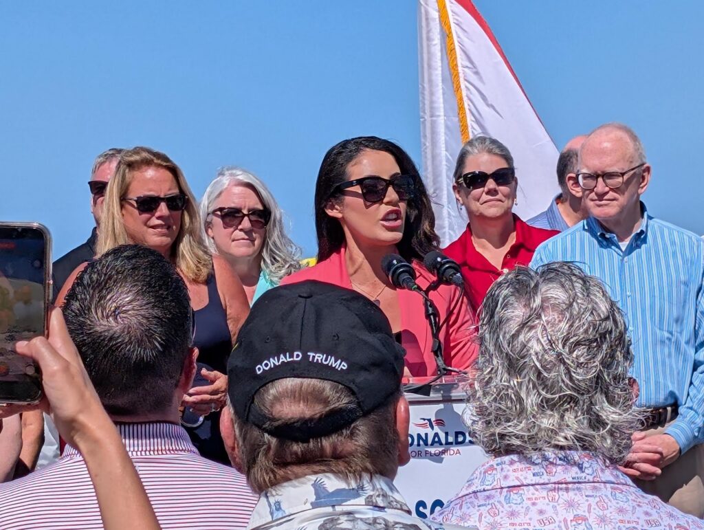 Woman speaking at outdoor political rally podium