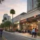 Outdoor dining along palm-lined city street at sunset