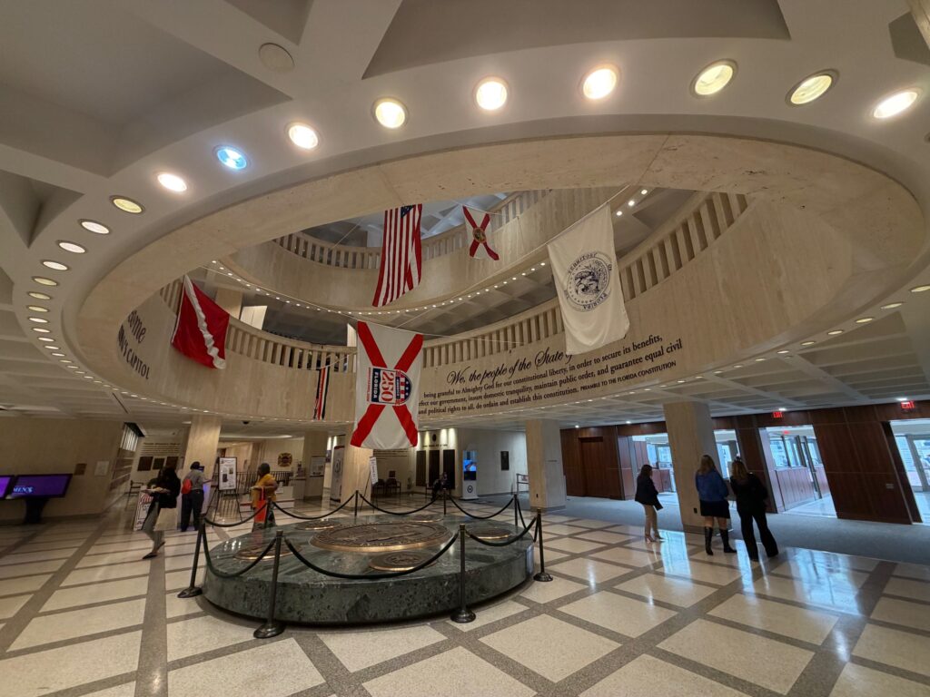 Interior rotunda of state capitol building with flags