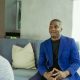 Man in blue blazer talking on couch