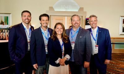 Five professionals posing at conference event indoors