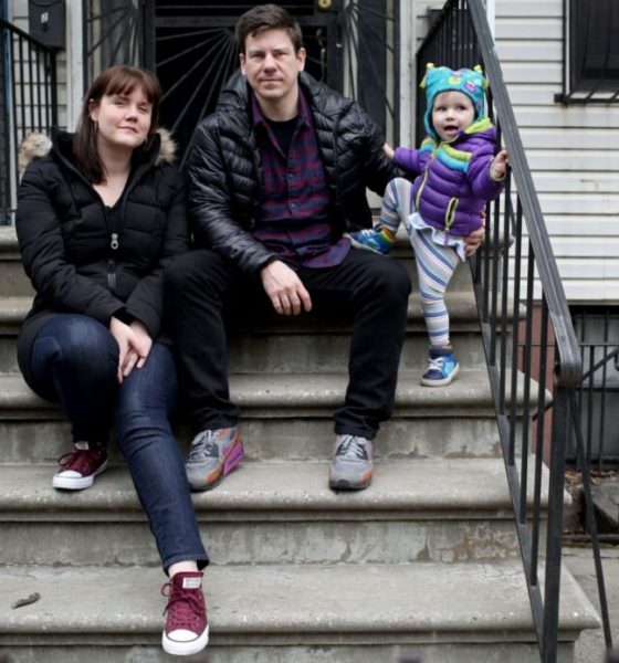 Family sitting on urban stoop with toddler