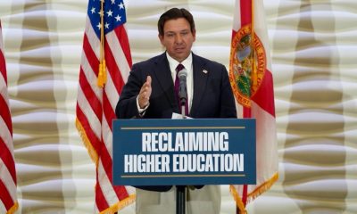 Man speaking at podium with U.S. flags