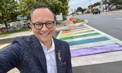 Man taking selfie at rainbow crosswalk