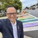 Man taking selfie at rainbow crosswalk