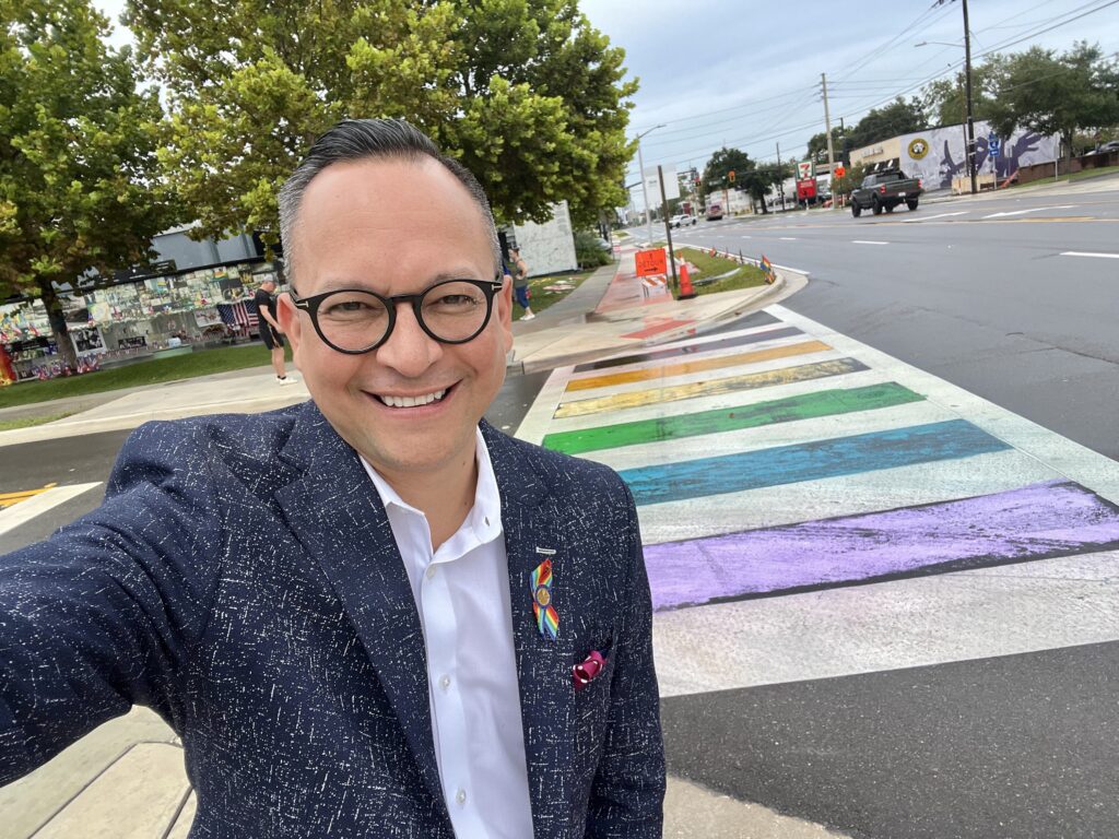 Man taking selfie at rainbow crosswalk