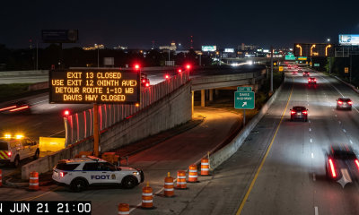 Highway exit closure sign at night with cones