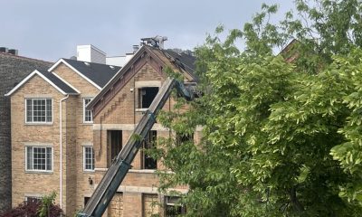 Worker repairing roof on brick house