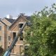 Worker repairing roof on brick house