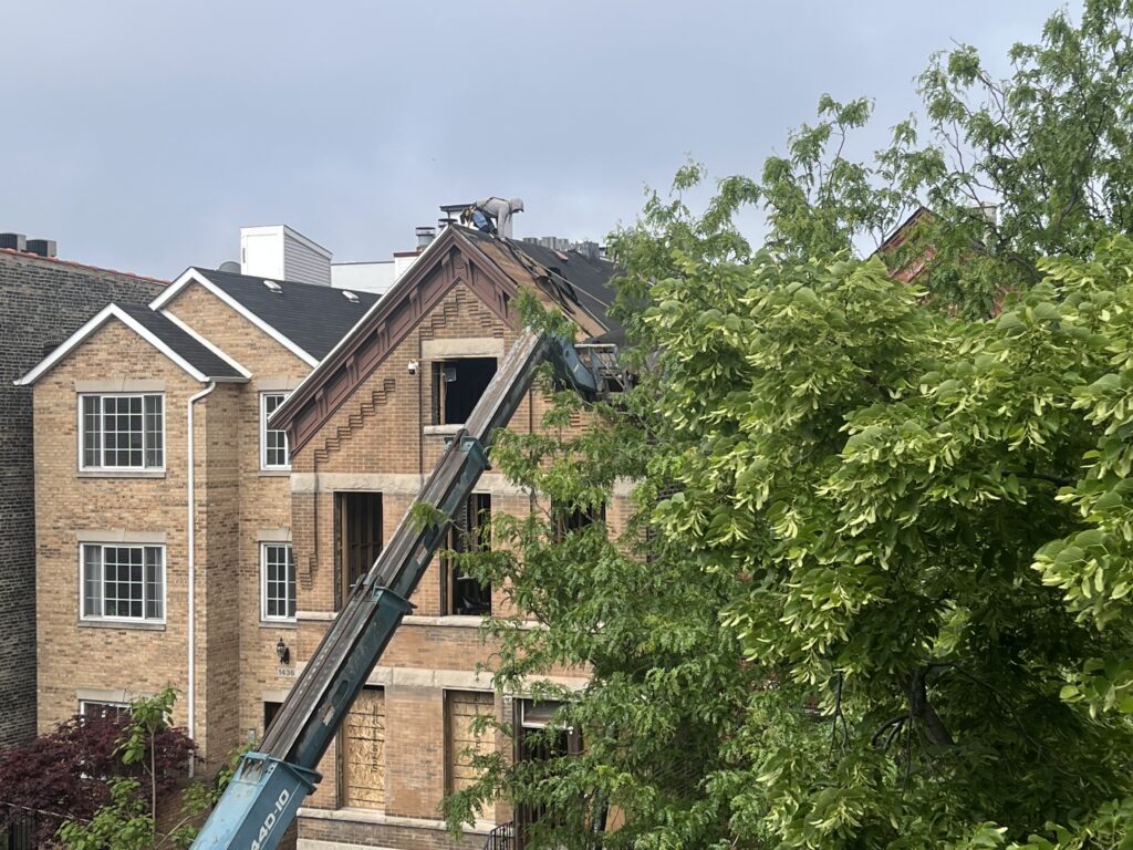 Worker repairing roof on brick house