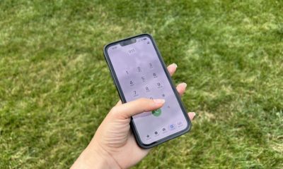 Hand dialing 911 on smartphone outdoors