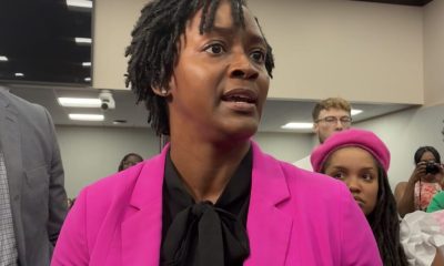 Woman in pink blazer speaking indoors