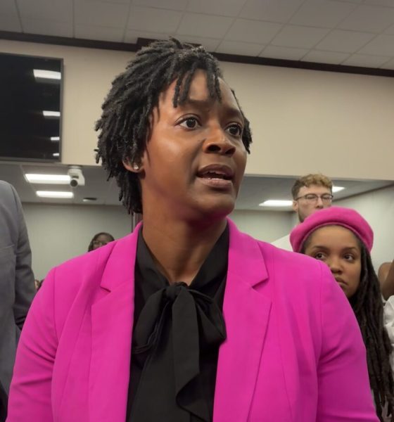 Woman in pink blazer speaking indoors