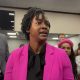 Woman in pink blazer speaking indoors