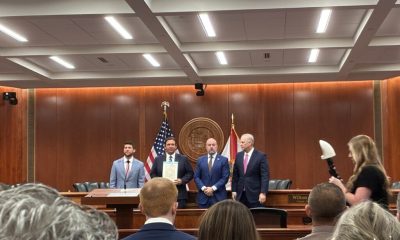 Officials holding signed document in government chamber