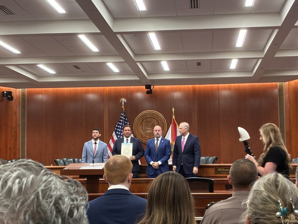 Officials holding signed document in government chamber