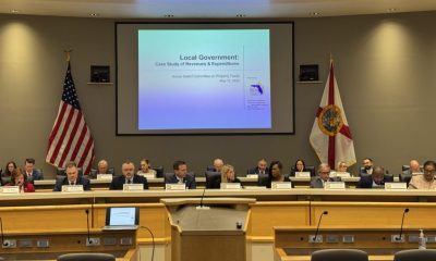 Government panel meeting with presentation and flags