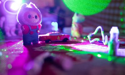 Toy figurine with red car under colorful lights