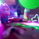 Toy figurine with red car under colorful lights