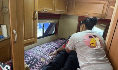 Woman assisting person lying on RV bed
