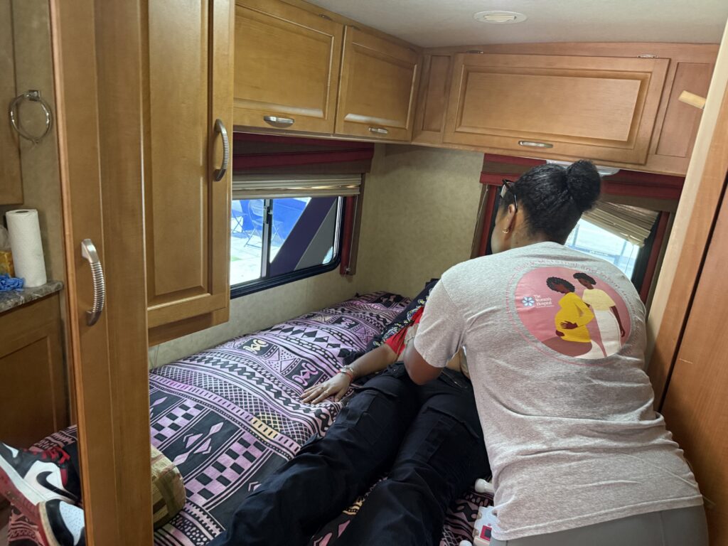 Woman assisting person lying on RV bed
