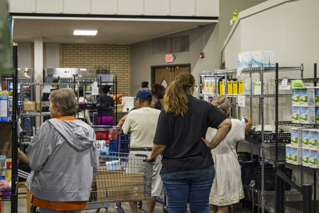 People shopping at community food pantry shelves