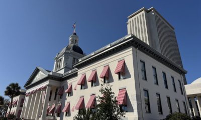 Historic capitol building with red striped awnings