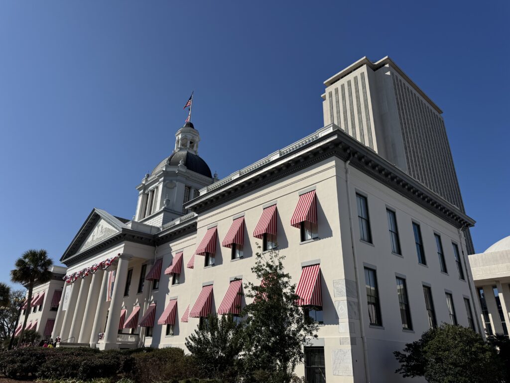 Historic capitol building with red striped awnings