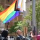 People raising rainbow Pride flag in city