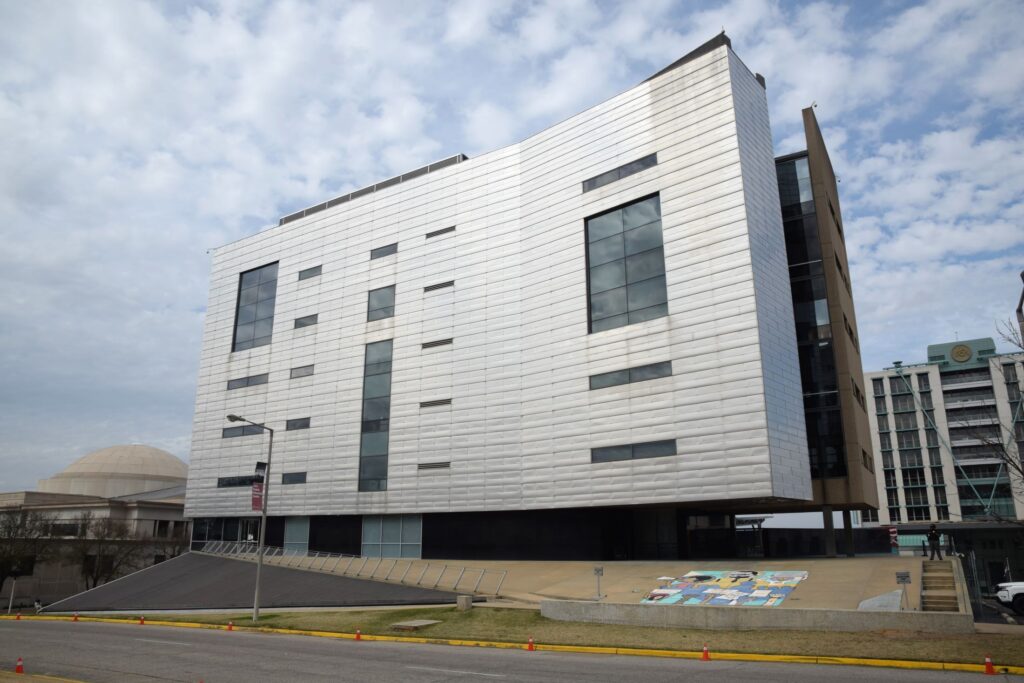 Modern white building with narrow windows and raised base