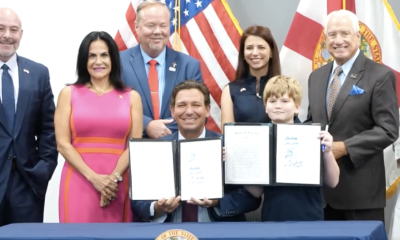 Officials and boy holding signed documents