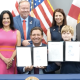 Officials and boy holding signed documents