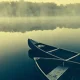 Two canoes on a misty calm lake
