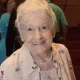 Smiling elderly woman wearing floral blouse and pearls