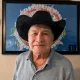 Older man in cowboy hat indoors