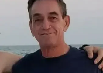 Man smiling by the ocean at sunset