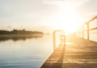 Wooden dock at sunrise over calm lake