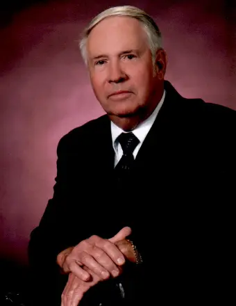 Older man in suit against pink backdrop